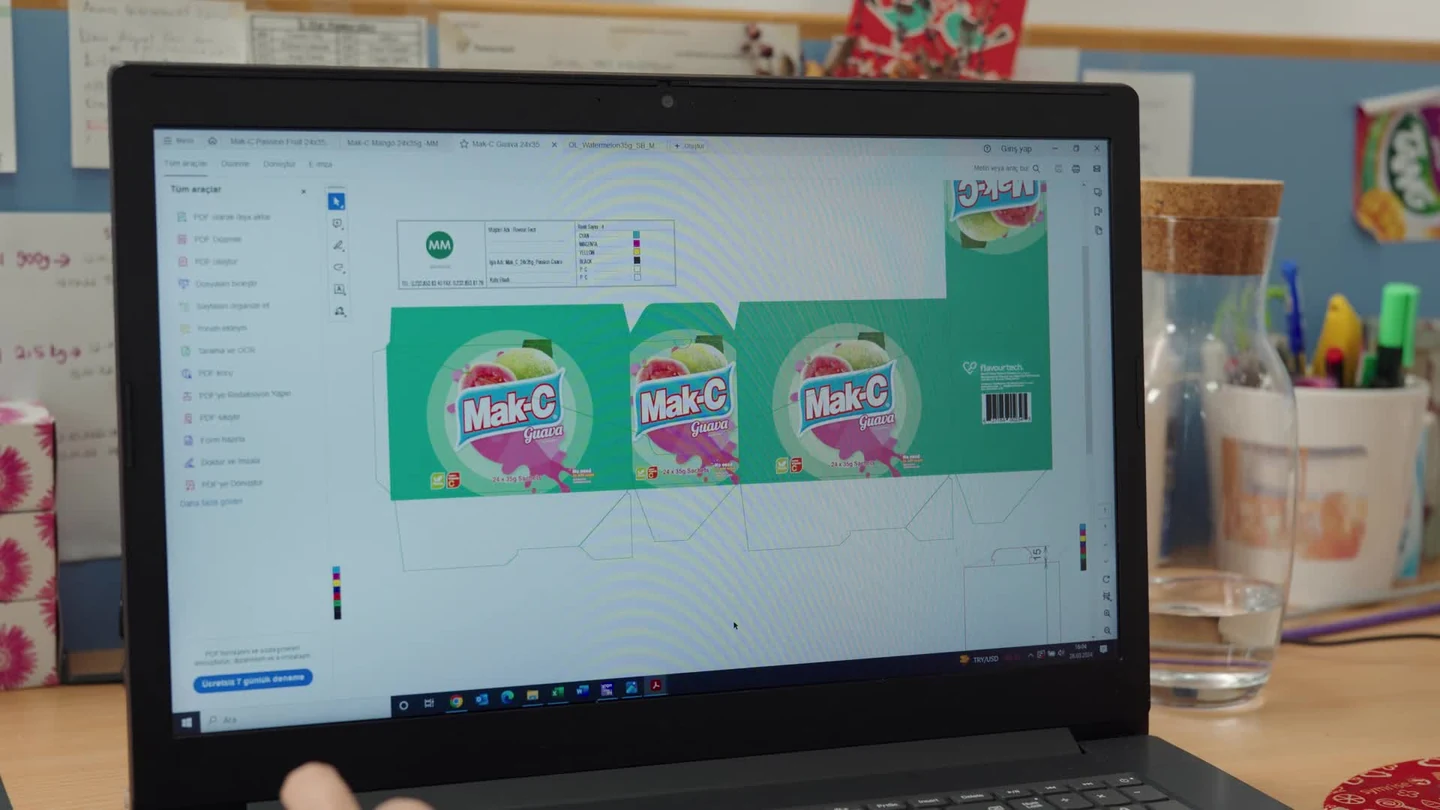 Mak-C packaging artwork at a FlavourTech office workstation